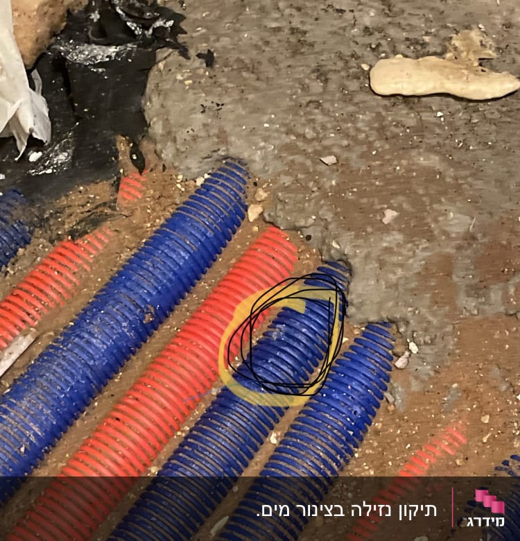 צינורות פלסטיק כחולים ואדומים על רצפה מלוכלכת